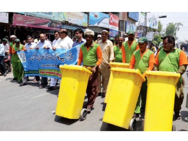 fwmc workers push waste bins during an awareness walk for cleanliness in faisalabad photo express fwmc workers push waste bins during an awareness walk for cleanliness in faisalabad photo express