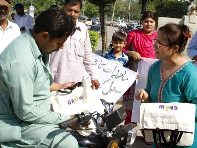 activist of an ngo distribute cloth bags to promote environment friendly practices at jinnah avenue photo express activist of an ngo distribute cloth bags to promote environment friendly practices at jinnah avenue photo express
