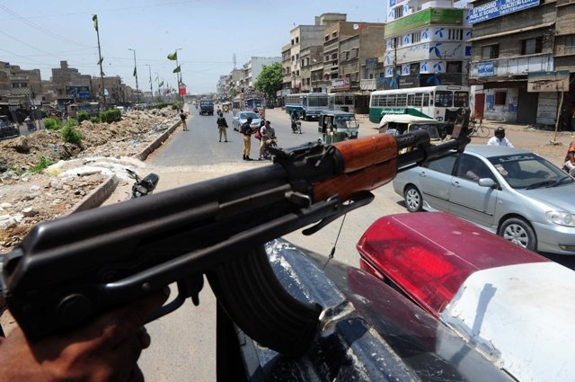 policemen stand at a security check point on a street in karachi photo afp