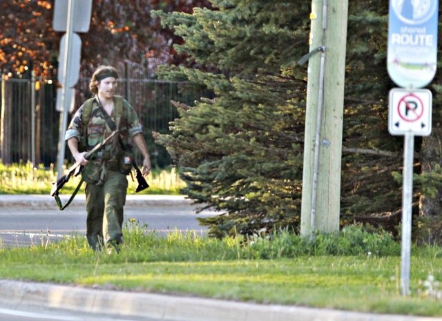 a heavily armed man that police have identified as justin bourque walks on hildegard drive in moncton new brunswick june 4 2014 after several shots were fired in the area photo reuters