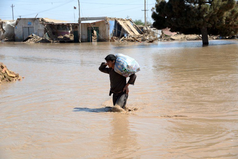 a file photo of an afghan man walking through a flooded area in northern afghanistan photo afp