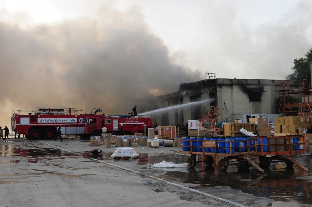 smoke rises after militants launched an assault at jinnah international airport in karachi photo afp