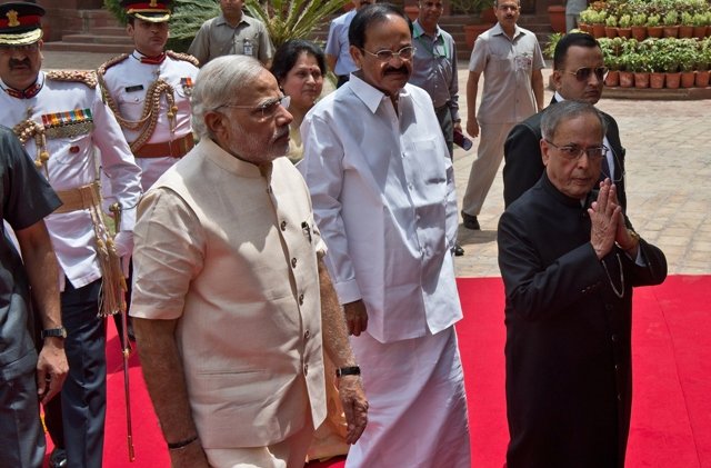 indian president pranab mukherjee gestures a greeting as he arrives with indian prime minster narendra modi to address the joint session of parliament in new delhi photo afp
