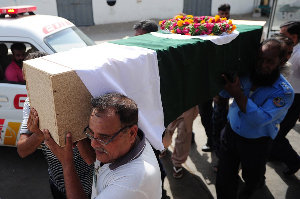 pakistani airport security force asf personnel and family members carry the coffin of a colleague killed in an assault by militants on karachi airport and to be flown to islamabad at the airport in karachi on june 9 2014 photo afp