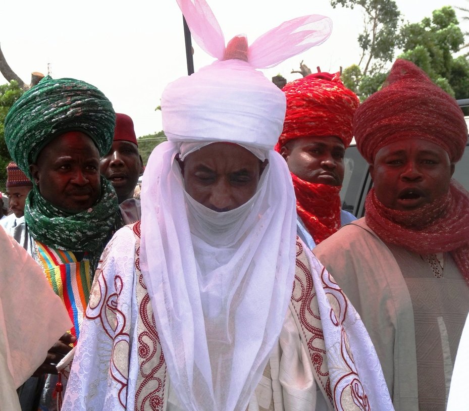 the new emir of the ancient northern nigerian city of kano and former governor of central bank sanusi lamido sanusi c walks out of the africa house hall at the kano state government house after receiving his letter of appointment as the new emir of kano from the state governor on june 9 2014 photo afp