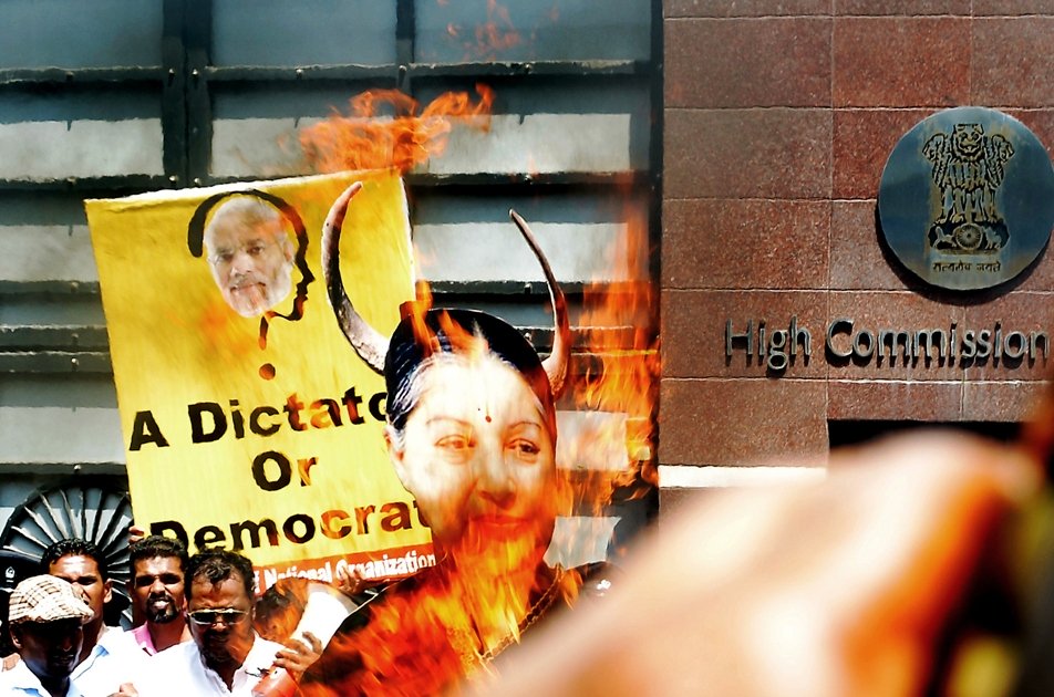 sri lankan pro government supporters burn a larger than life photograph of tamil nadu state chief minister jayalalitha jayaram during a demonstration outside the indian high commission in colombo on june 10 2014 the activists denounced india s new prime minister narendra modi and jayaram for allegedly interfering in sri lanka s domestic politics photo afp