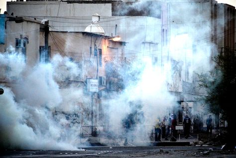 smoke from tear gas grenades cover bahraini shia muslim youths standing at a makeshift barricade photo afp file