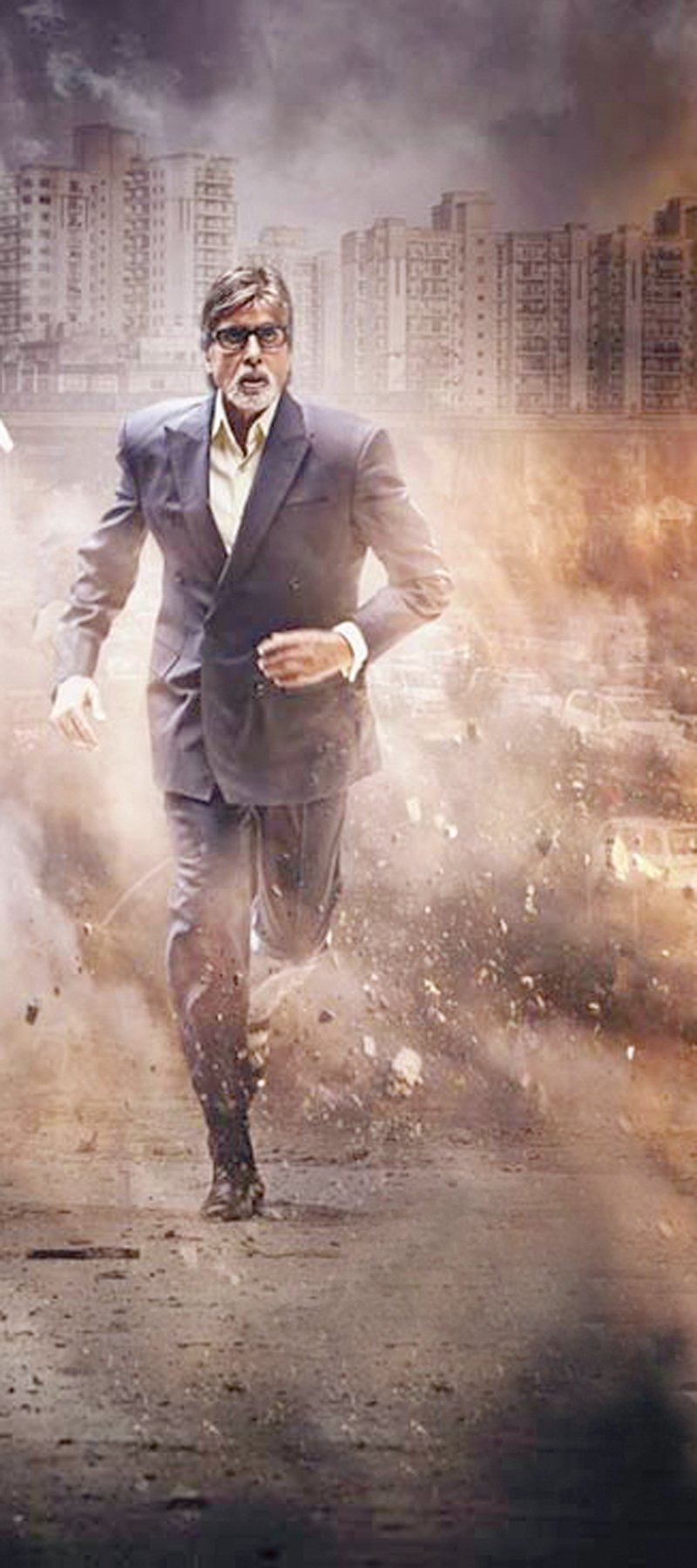 the first look of yudh presents an intense looking amitabh running away in a blue suit against the backdrop of skyrising buildings photo file