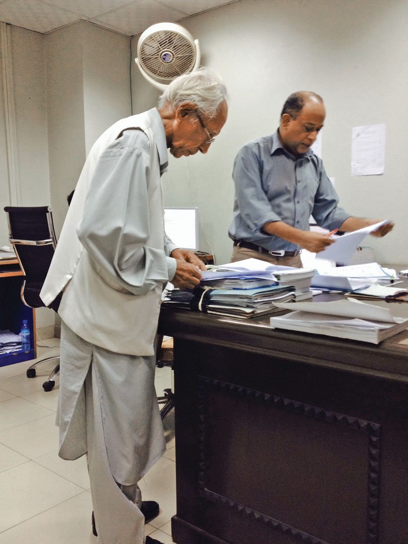 an 80 year old masood ahmed jafri pores over the next karachi city government budget with deputy director saghir ahmed on thursday at civic centre the 2014 2015 budget is likely to be announced in two weeks photo mahim maher express