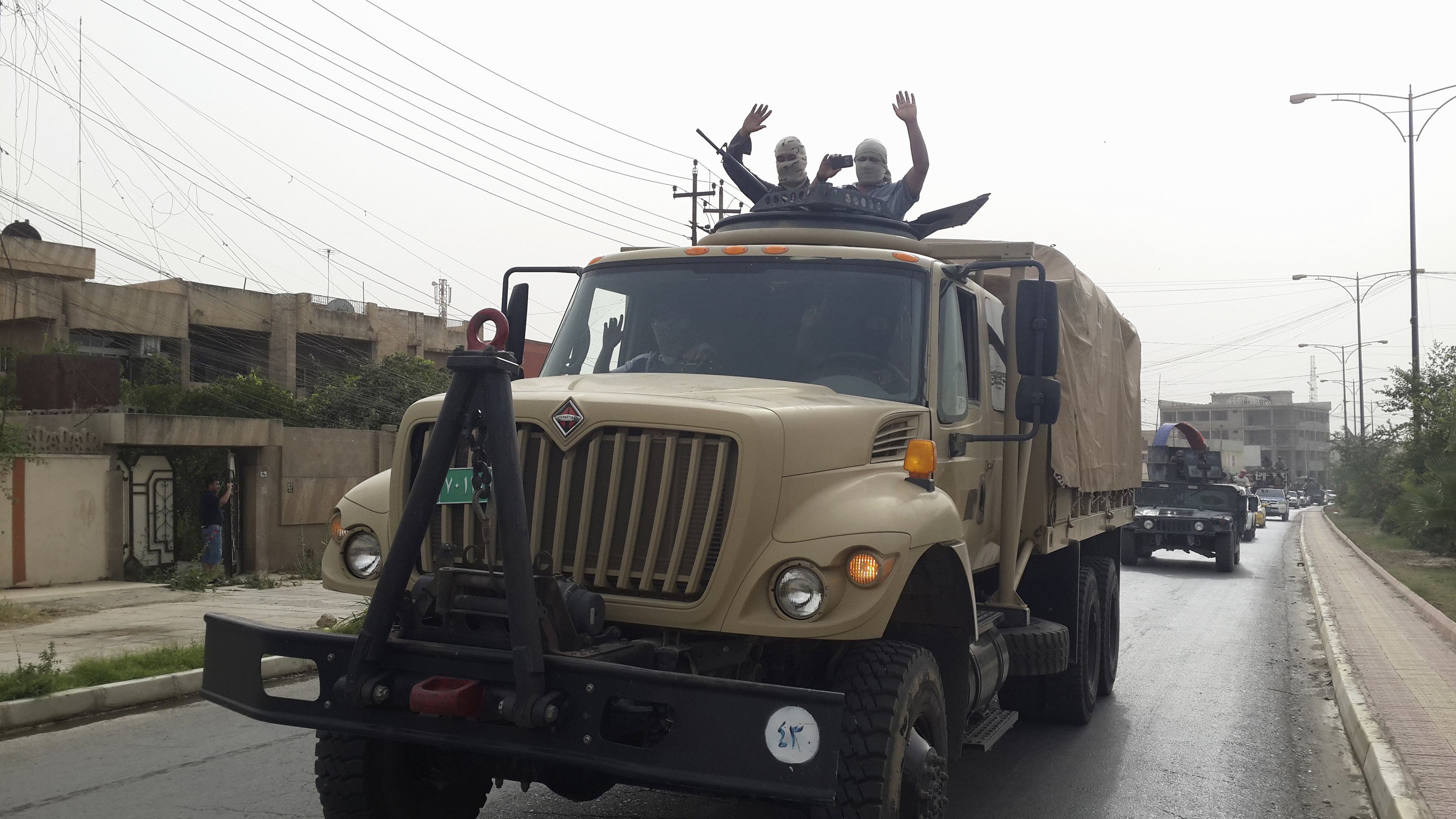 fighters of the islamic state of iraq and the levant isil celebrate on vehicles taken from iraqi security forces at a street in city of mosul june 12 2014 photo reuters