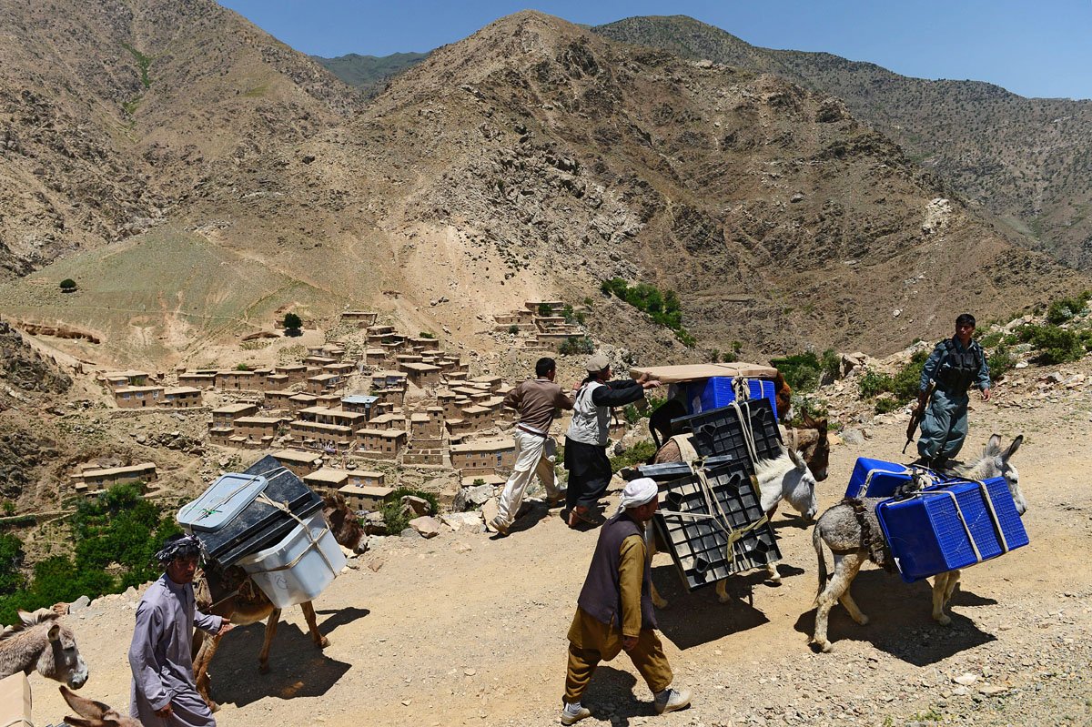 afghan villagers lead donkeys carrying ballot boxes and other election materials to polling stations not accessible by road along a path in the shotul district of panjshir province on june 13 2014 photo afp