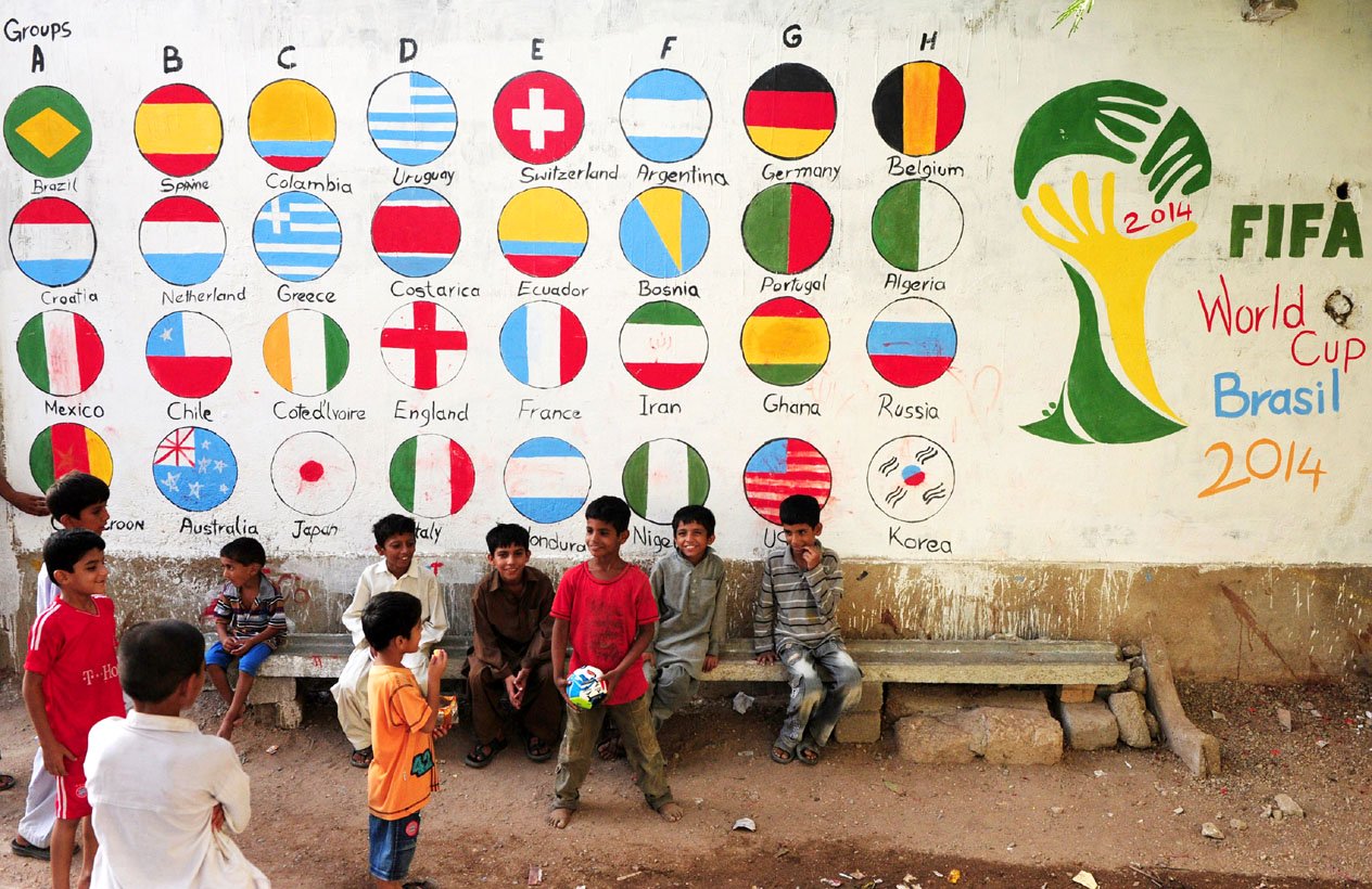 in this photograph taken on june 12 2014 children play football in front of a mural celebrating the world cup painted on the wall of a house in karachi photo afp