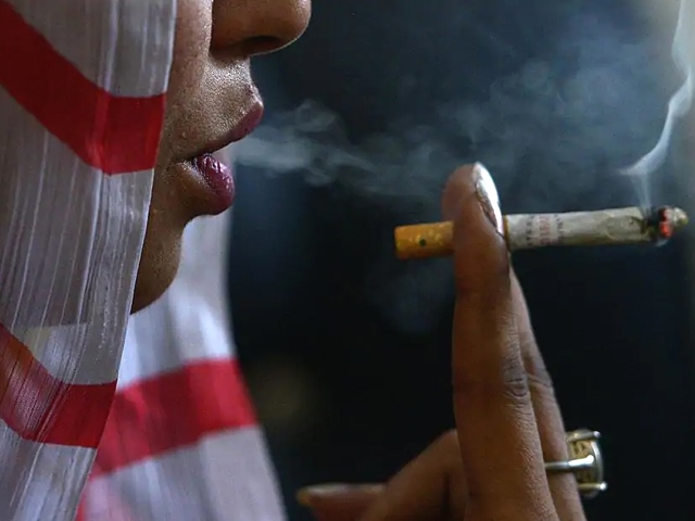 this picture taken on october 25 2017 shows a pakistani woman smoking a hashish cigarette in peshawar photo afp