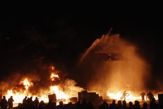 in this file photo a pro european protester throws tyres into a fire during street violence in kiev photo reuters