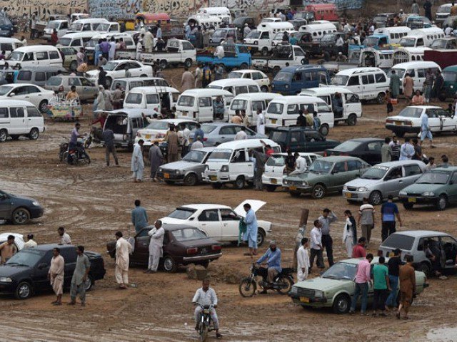 n this photograph taken on july 26 2015 people gather around cars at the sunday car market in karachi photo afp