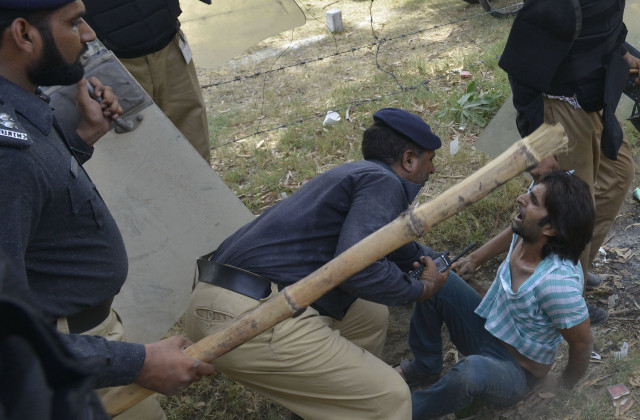 stick and shield wielding policemen detain an unrmed protester photo afp stick and shield wielding policemen detain an unrmed protester photo afp