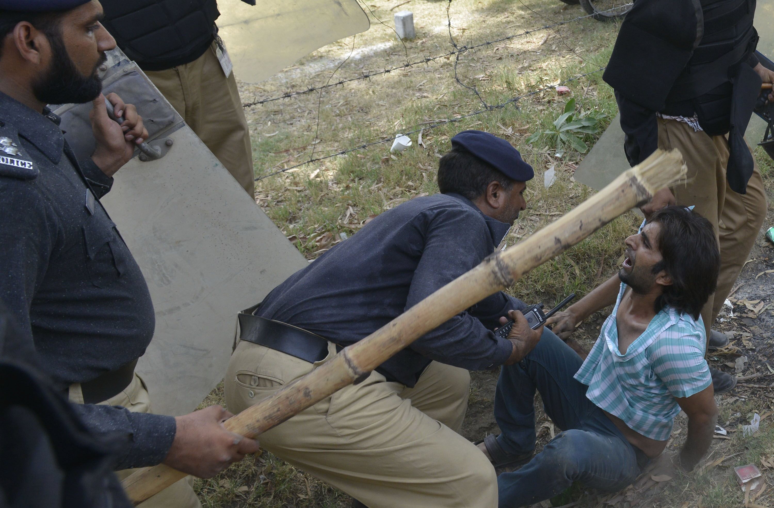 stick and shield wielding policemen detain an unrmed protester photo afp