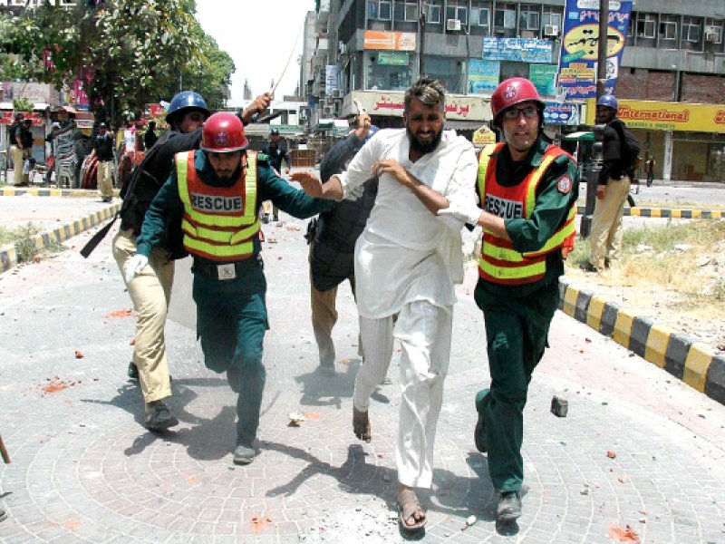 rescue 1122 officials helping a pakistan awami tehreek worker as the police continue to baton charge photo online