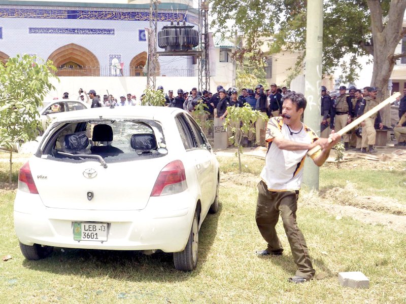 gullu butt breaks windows of a car during the clash between police and pat workers photo inp