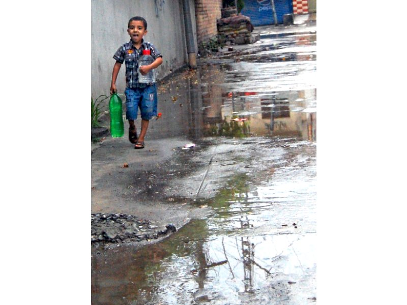 a boy juggles with bottles while fetching drinking water from a filtration plant as the twin cities received first pre monsoon rain on wednesday photo muhammad javaid express