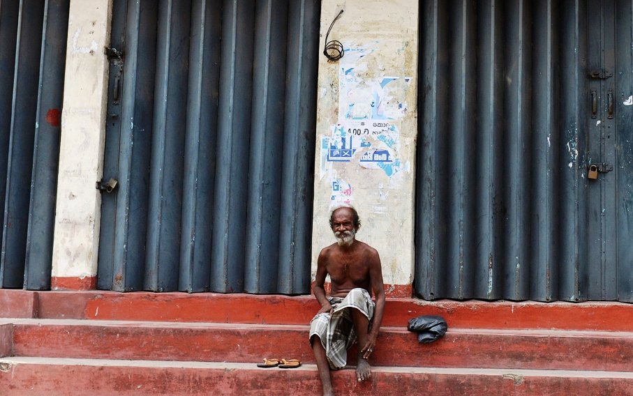 a sri lankan labourer looks on amid shuttered muslim owned shops closed in protest following deadly communal violence in colombo on june 19 2014 photo afp