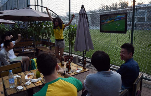 chinese and brazilian football fans watch the opening match of the world cup live on a tv screen in a beijing park on june 13 2014 photo afp chinese and brazilian football fans watch the opening match of the world cup live on a tv screen in a beijing park on june 13 2014 photo afp