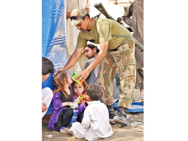 a soldier offers juice to children at an idps registration point photo app a soldier offers juice to children at an idps registration point photo app