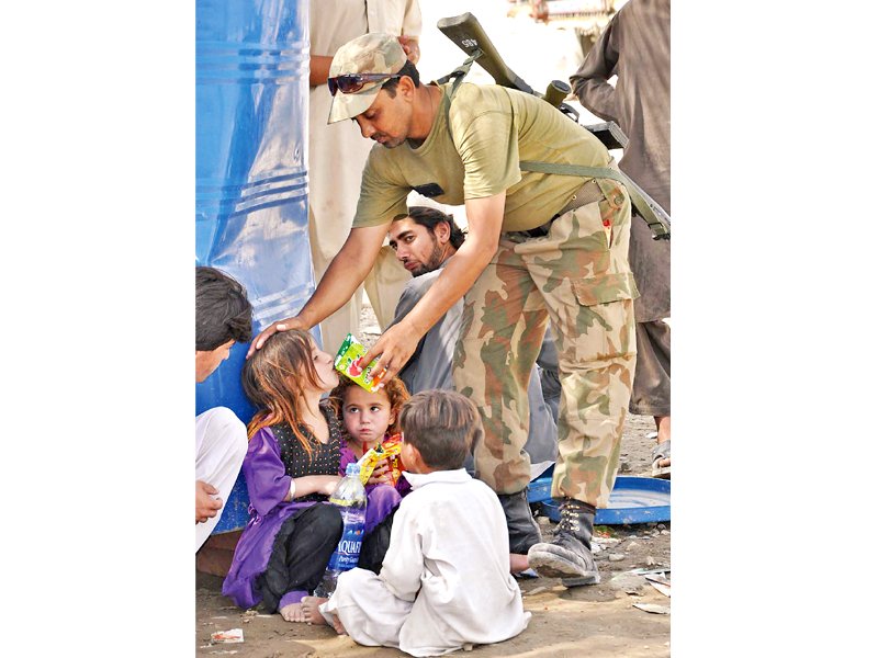 a soldier offers juice to children at an idps registration point photo app