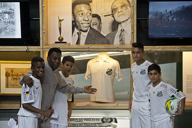 brazilian football legend pele poses with young players during the inauguration of the pele museum in santos some 70 km from sao paulo brazil on june 15 2014    photo afp