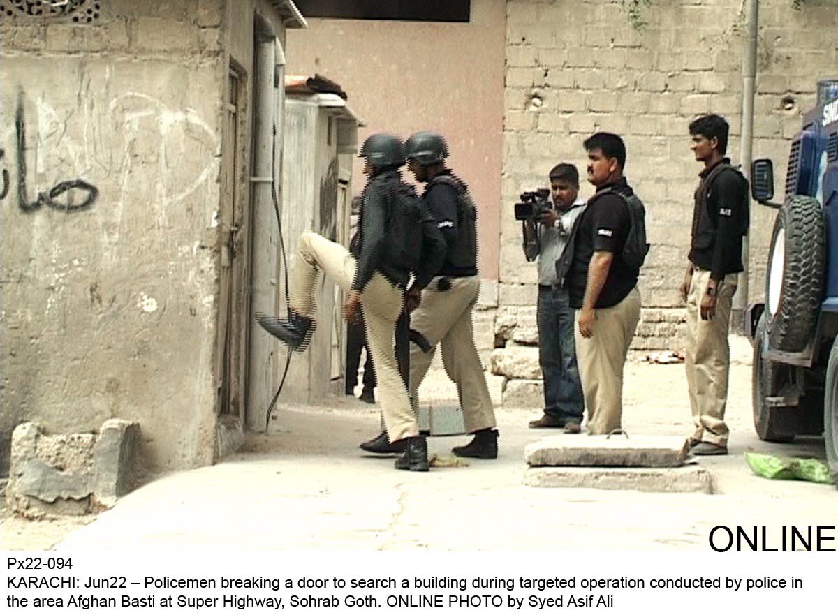 policemen breaking a door during a search operation in afghan basti sohrab goth photo online