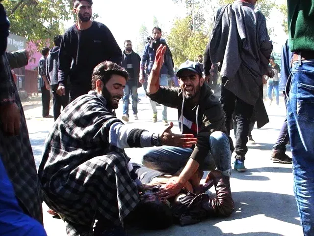 kashmiri men gesture as another lies on the ground after a blast near a residential house in kulgam on october 21 2018 photo afp kashmiri men gesture as another lies on the ground after a blast near a residential house in kulgam on october 21 2018 photo afp
