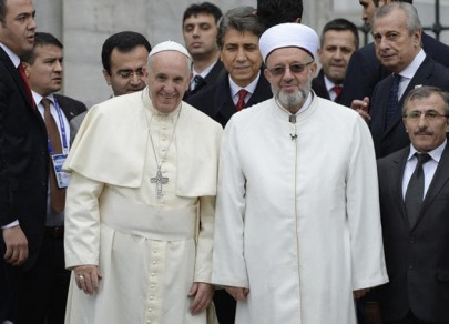 pope clasps hands in reflection in istanbul mosque