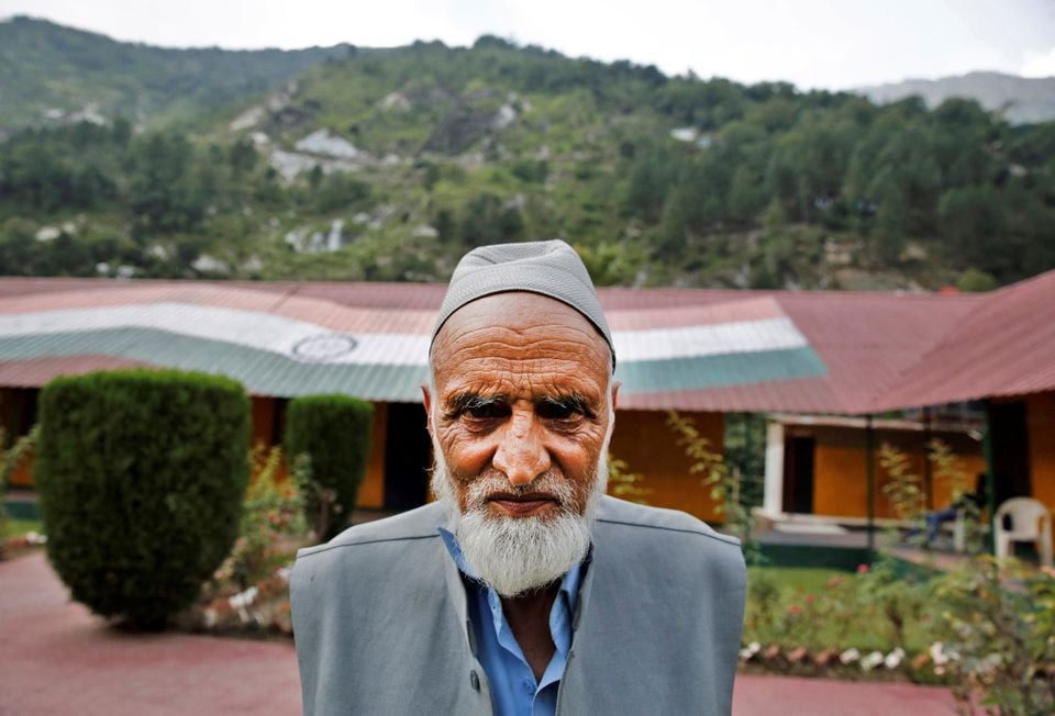 Abdul Rashid Khokhar, 73, a village council head, poses for a photograph near the Line of Control between India and Pakistan in Teetwal in north Kashmir's Kupwara district August 8, 2022. REUTERS