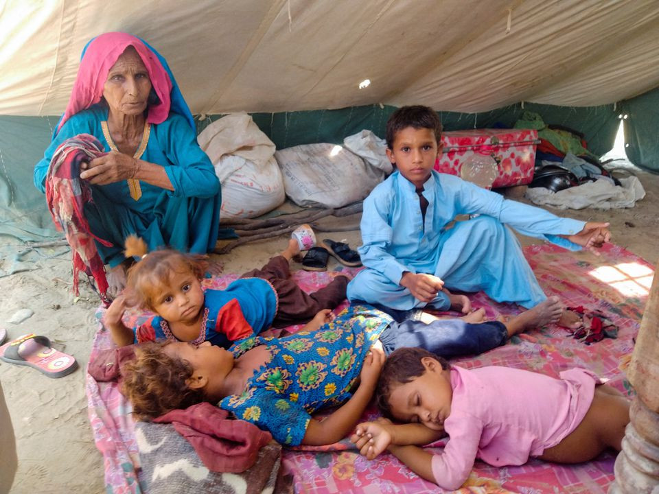 a woman who is a flood victim looks after children while taking refuge at a relief camp following rains and floods during the monsoon season in sehwan pakistan september 9 2022 reuters