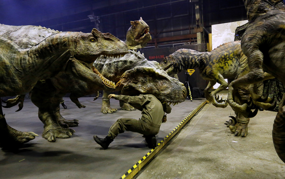 Japan's ON-ART Corp's eight metre tall human-operated walking dinosaur robot 'TRX03' (C) performs with other robots at the company's studio in Tokorozawa, Japan. PHOTO: REUTERS