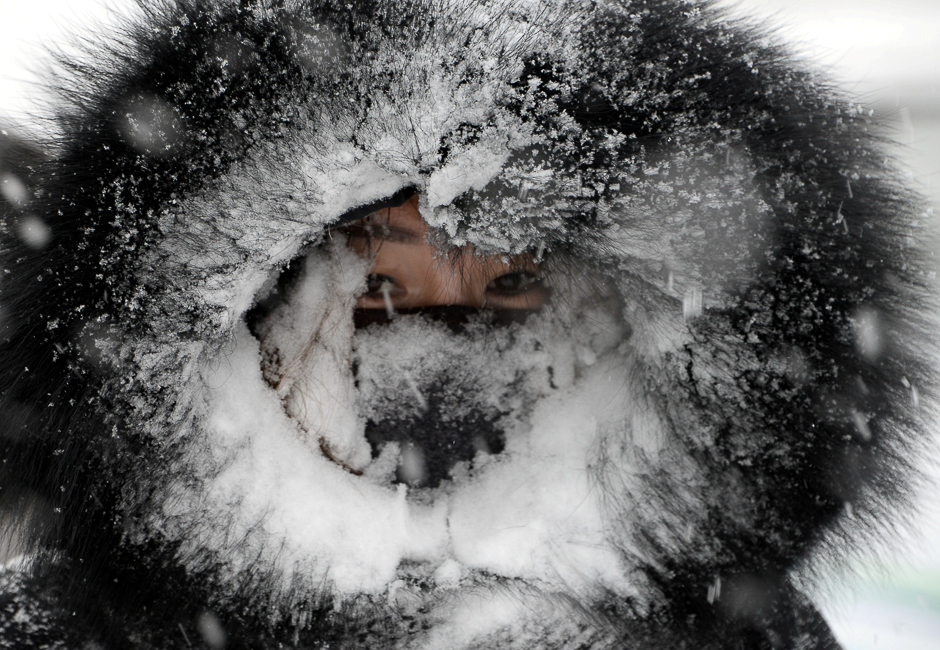 A woman rides a vehicle amid snow in Bozhou, Anhui province, China. PHOTO: REUTERS