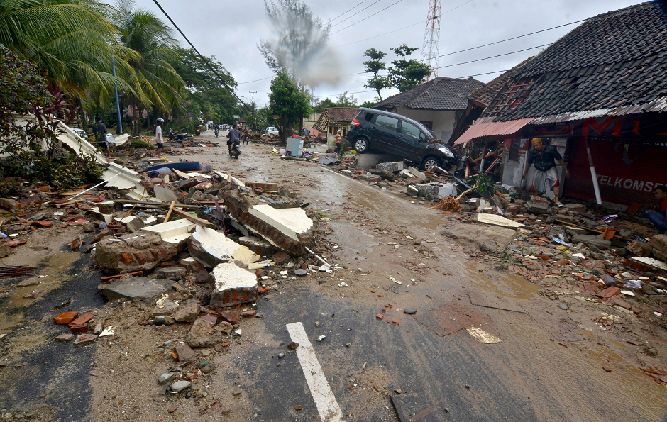 Residents inspect damaged buildings in Carita on December 23, 2018, after the area was hit by a tsunami on December 22 following an eruption of the Anak Krakatoa volcano. PHOTO: AFP