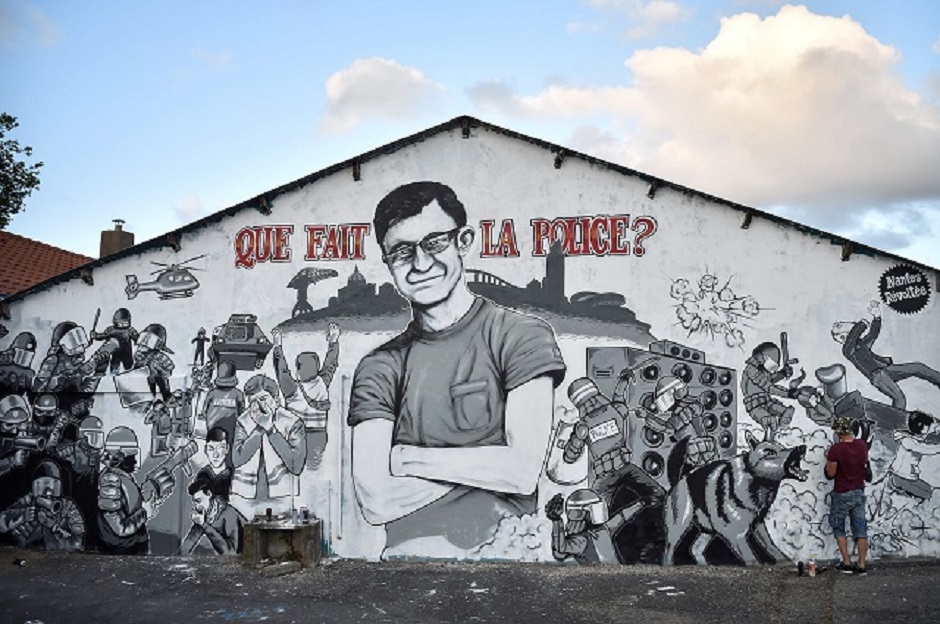 A graffiti artist works on a mural depicting an image of a missing man called Steve, standing crossed armed with a message that reads 'What is the police doing ?' in the western French city of Nantes. PHOTO: AFP