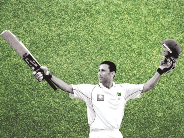 younis khan raises his bat and helmet as he celebrates after scoring a century against south africa photo afp