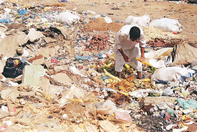 in this file photo a man forages for something to eat in a garbage dump in karachi photo arif soomro