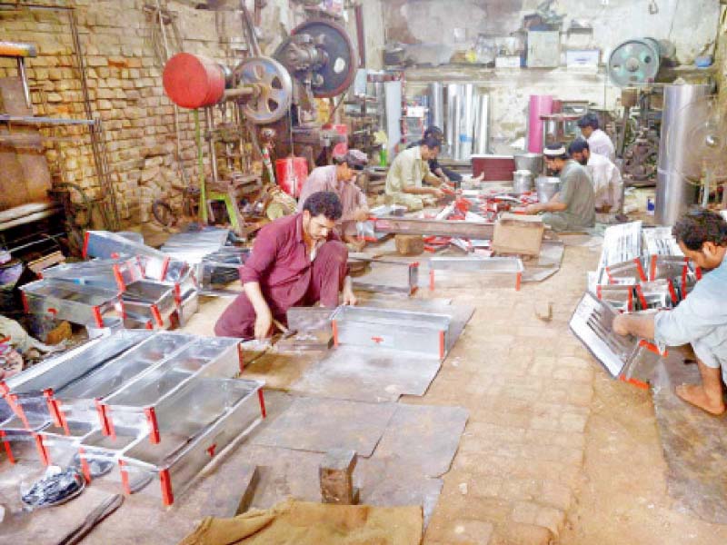 workers make charcoal grills at lohar bazaar or blacksmith market in rawalpindi photo app