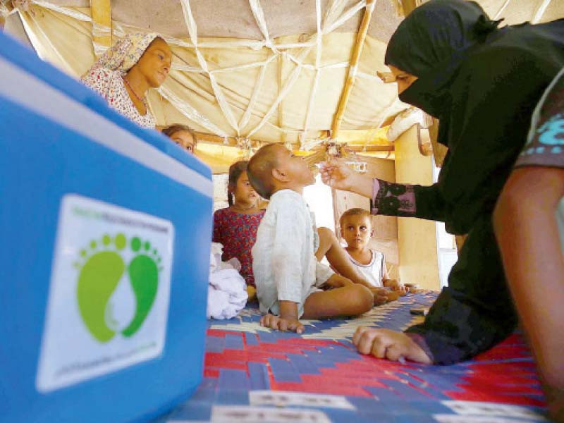 a health worker administers oral polio vaccine to a child at a slum in karachi photo app file