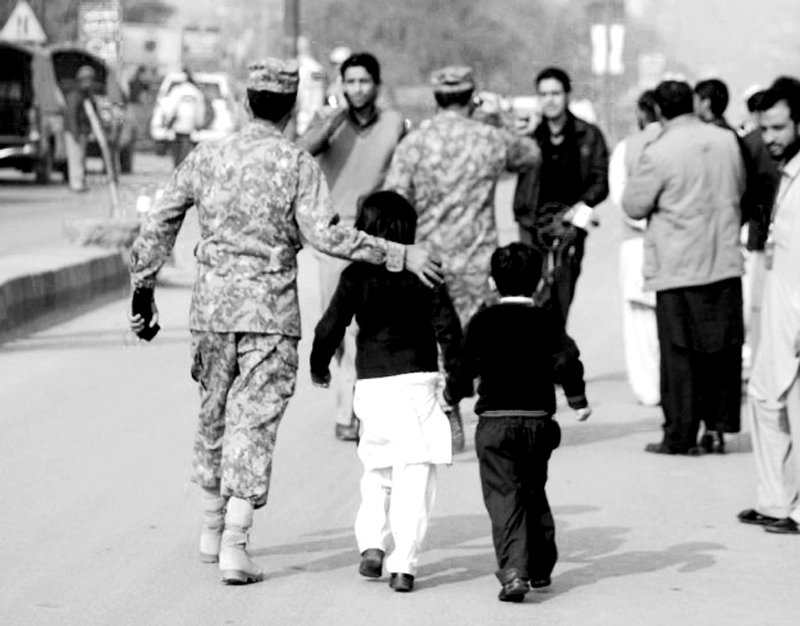 security official rescues students after the attack on army public school in peshawar photo file