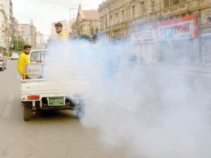 kmc employees carry out disinfectant spray on a road in karachi on monday photo express