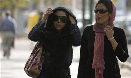 women adjust their headscarves as they walk along a sidewalk in tehran photo reuters