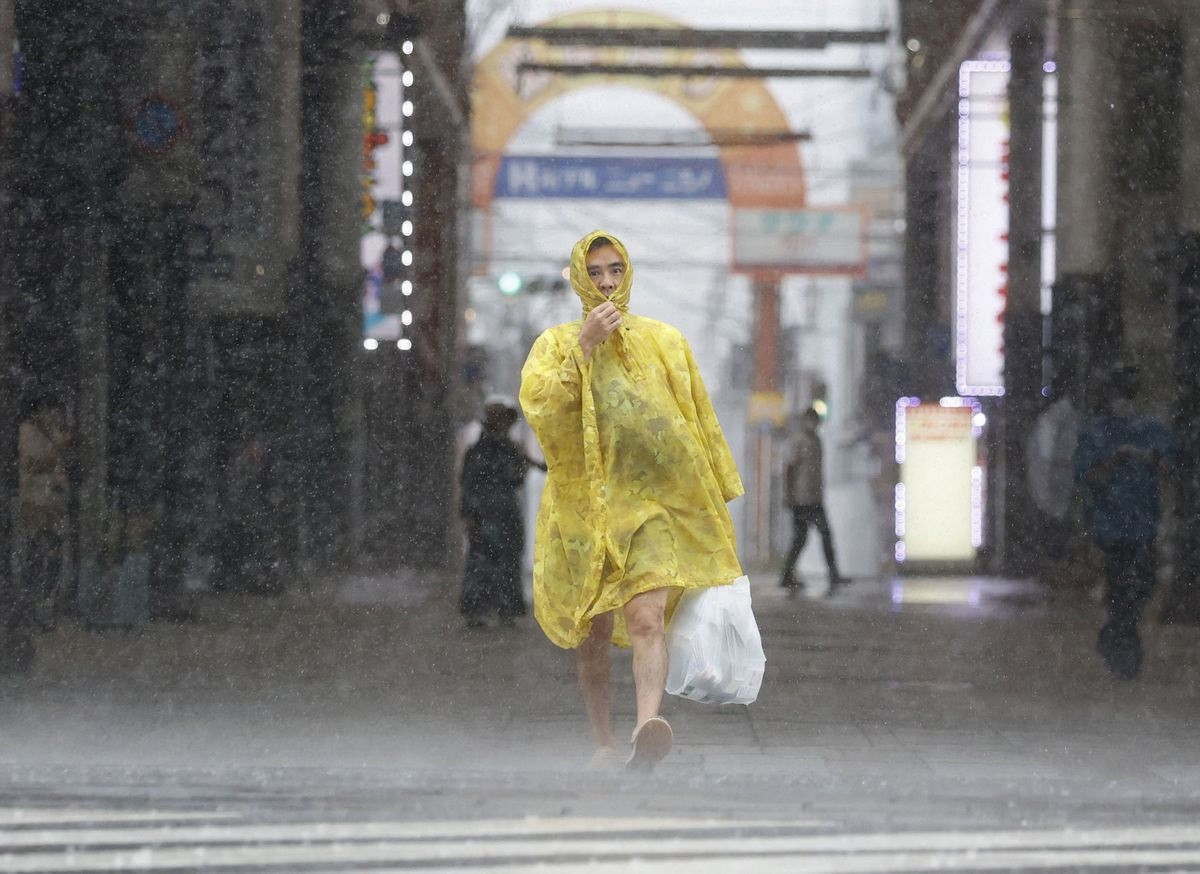 A man walks on the street in heavy rain and wind caused by Typhoon Nanmadol in Kagoshima on Japan's southernmost main island of Kyushu September 18, 2022, in this photo taken by Kyodo. Kyodo via REUTERS ATTENTION EDITORS - THIS IMAGE WAS PROVIDED BY A THIRD PARTY. MANDATORY CREDIT. JAPAN OUT. NO COMMERCIAL OR EDITORIAL SALES IN JAPAN