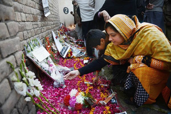 if you walk past the main gate of army public school aps and enter the main building you see thousands of messages flowers pictures and banners left there by parents relatives and general visitors including ngos photo afp