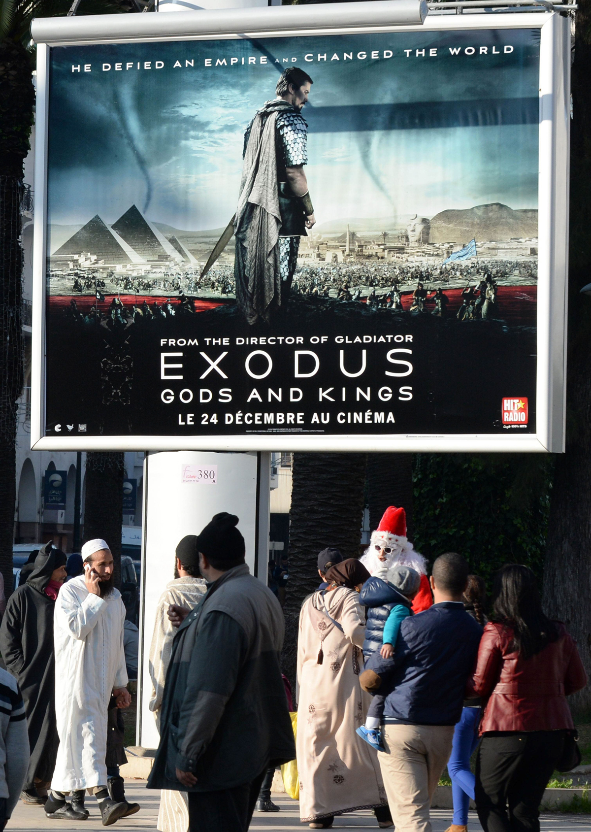 a picture taken on december 26 2014 shows people walking past a billboard for the hollywood biblical epic movie quot exodus gods and kings quot displayed in the moroccan capital rabat photo afp