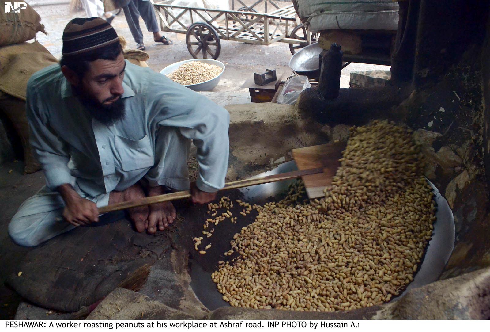 a man roasts peanuts in his store in peshawar peanuts are a good source of protein and amino acids which promote the growth of the foetus photo inp