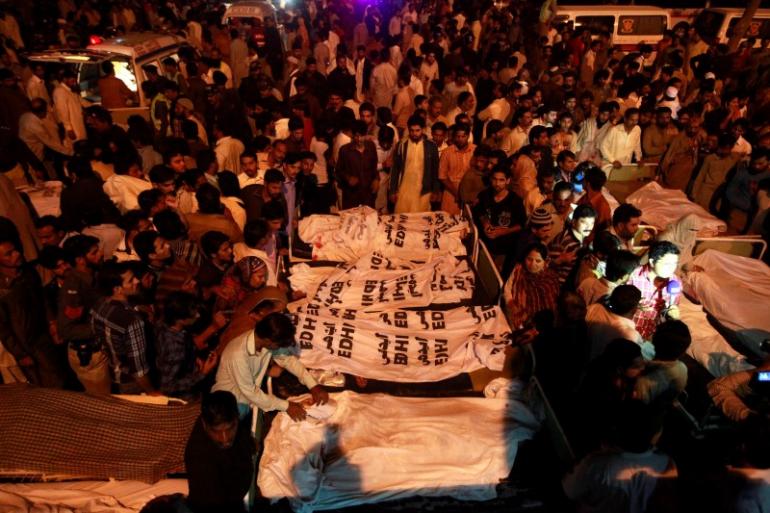 relatives gather beside the covered bodies of victims who were killed in suicide bomb attack in wagah border near lahore november 2 2014 photo reuters